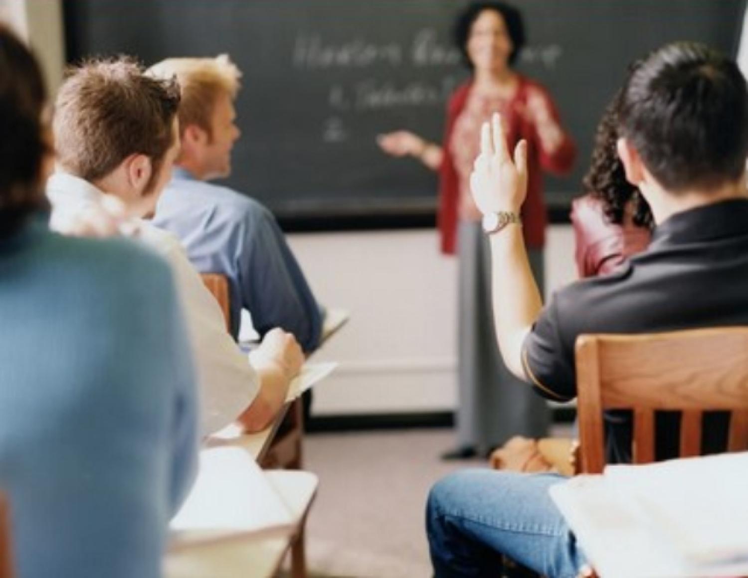 Student raising their hand in a classroom