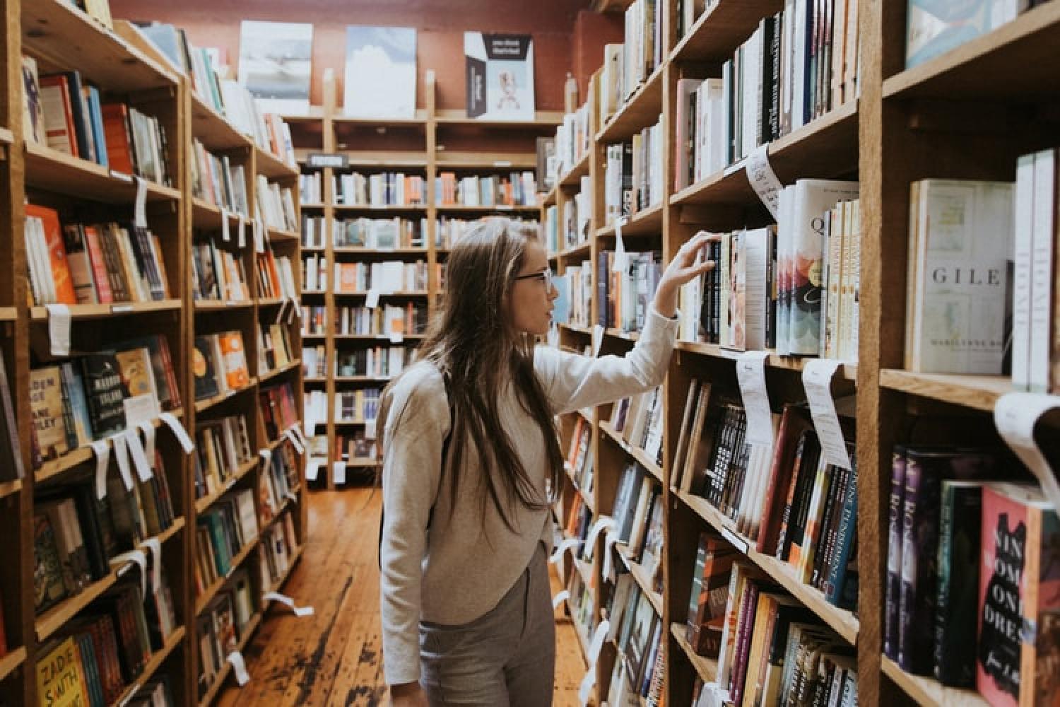Girl looking at books in library
