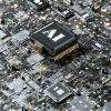 A giant computer chip on a complex motherboard has "AI" written across it.