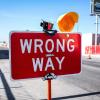 A red WRONG WAY sign