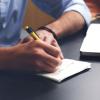 Person takes notes on a notepad