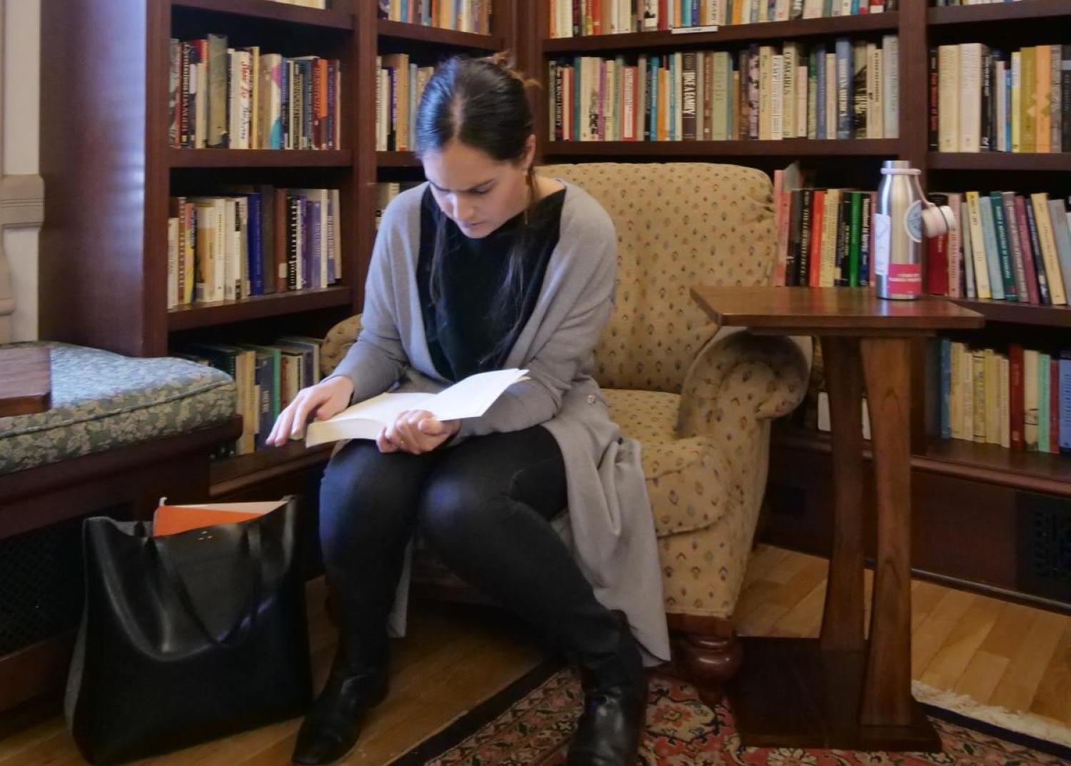Woman reading in front of bookcase