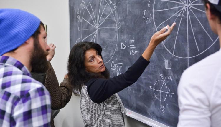 Professor and students at blackboard with math equations