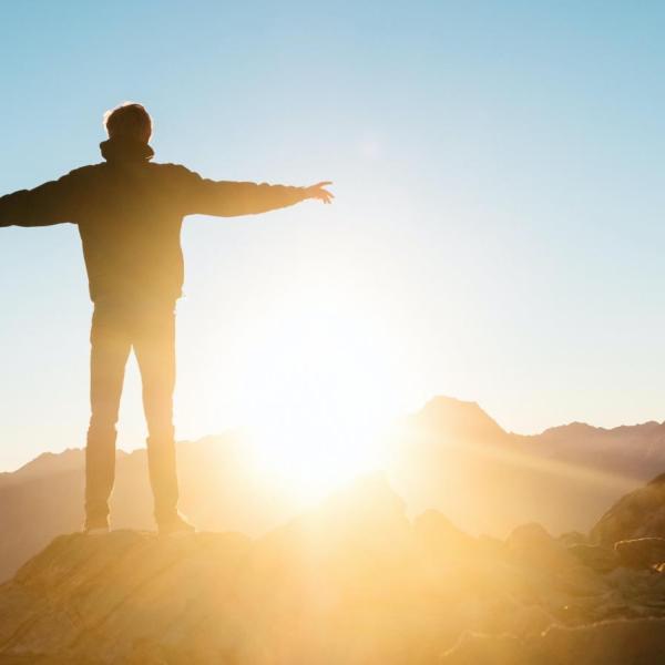 Person looking out over the view with the sunlight in front of them
