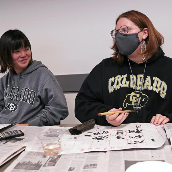 Two students of Chinese practice calligraphy