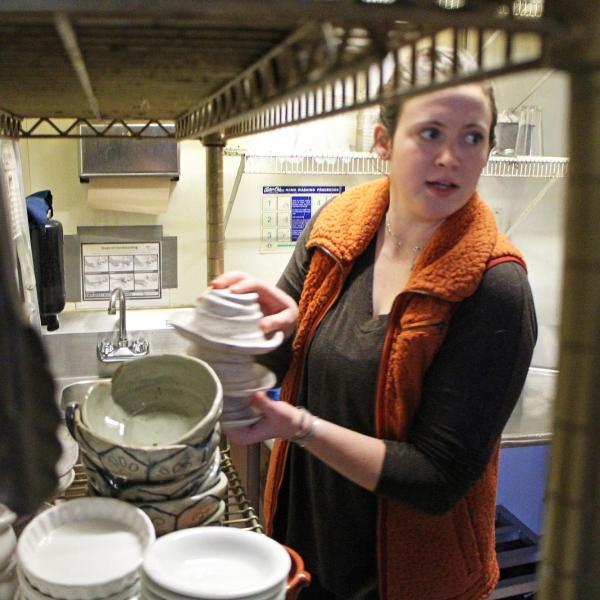 Emily Clark getting plates off shelf
