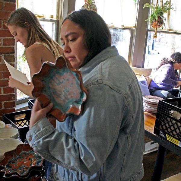Gigi Placeres looking at ceramic plate
