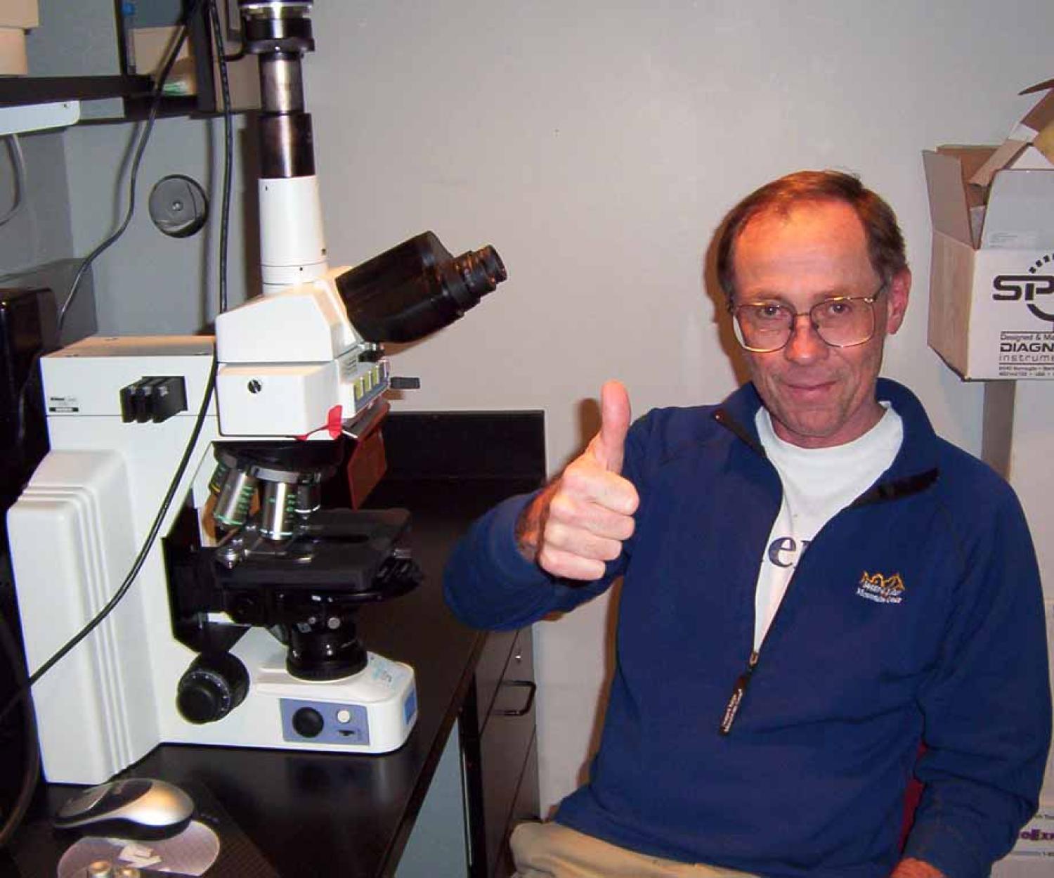 Norm Pace by his microscope