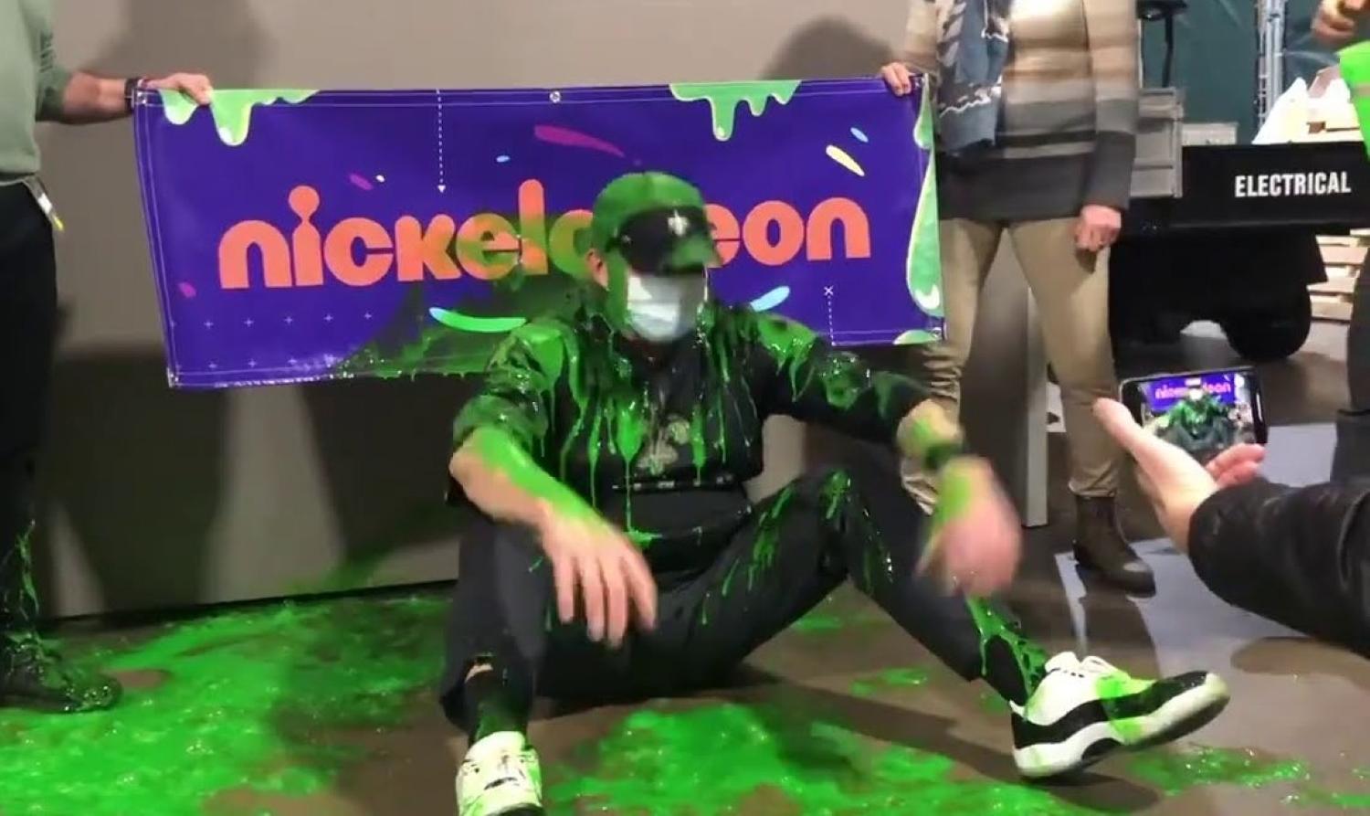 Sean Payton sitting on floor and doused in green slime.