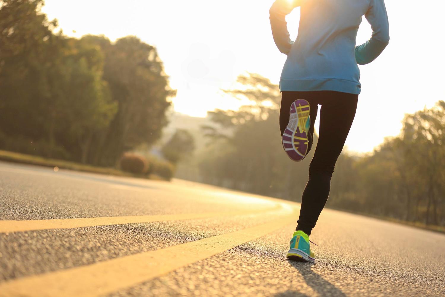 Person shown from back and shoulders down, running on road