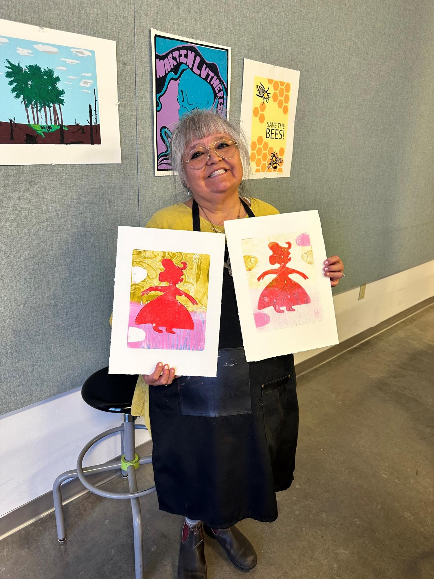 Melanie Yazzie holding two art prints
