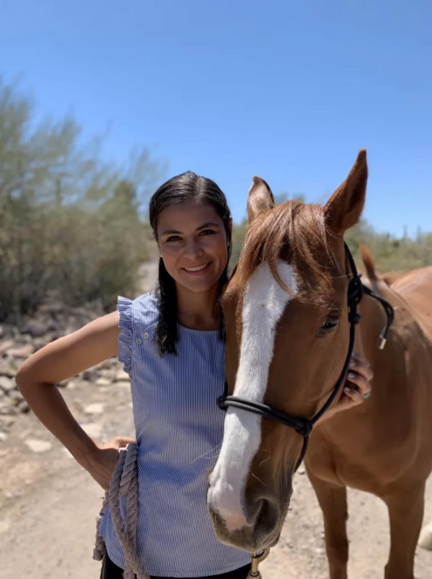 Kelsey John standing with brown horse