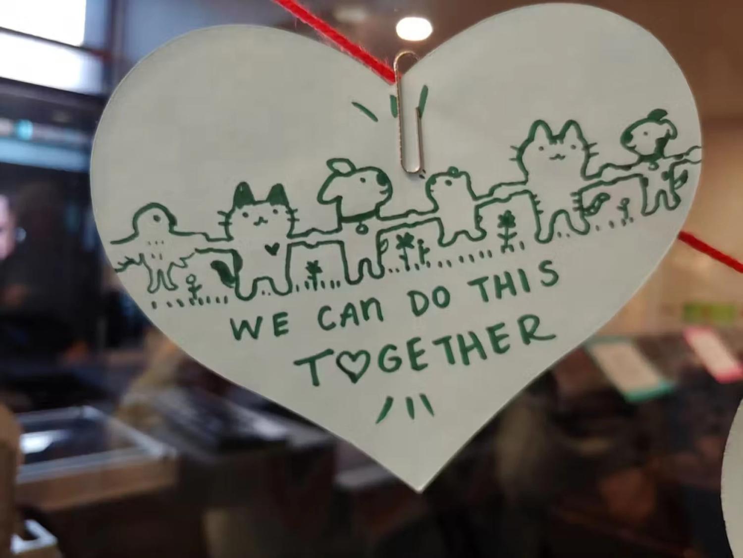 white paper heart with green child's writing and drawings