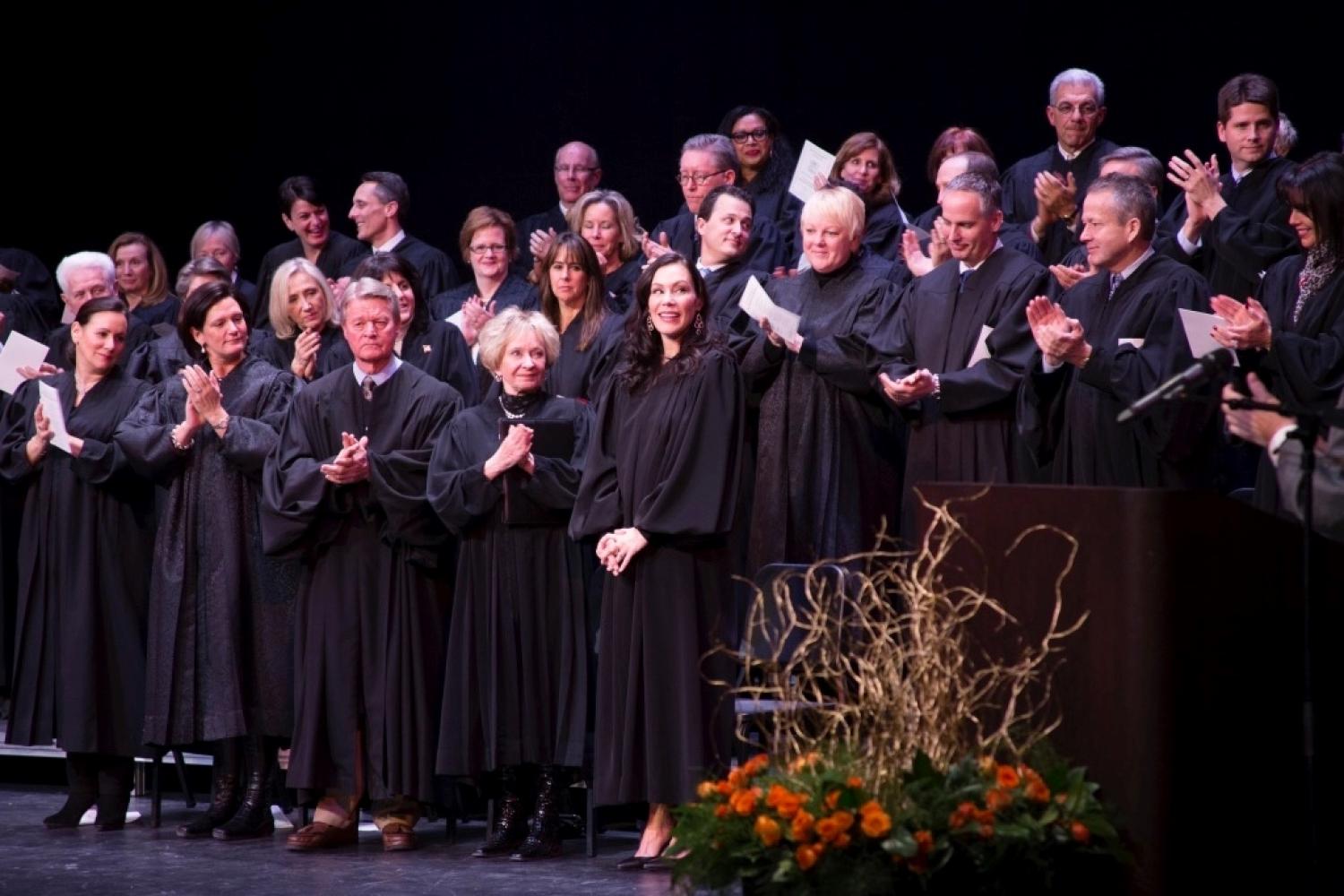 Maureen McGinnis in black judge robes with other judges at investiture ceremony
