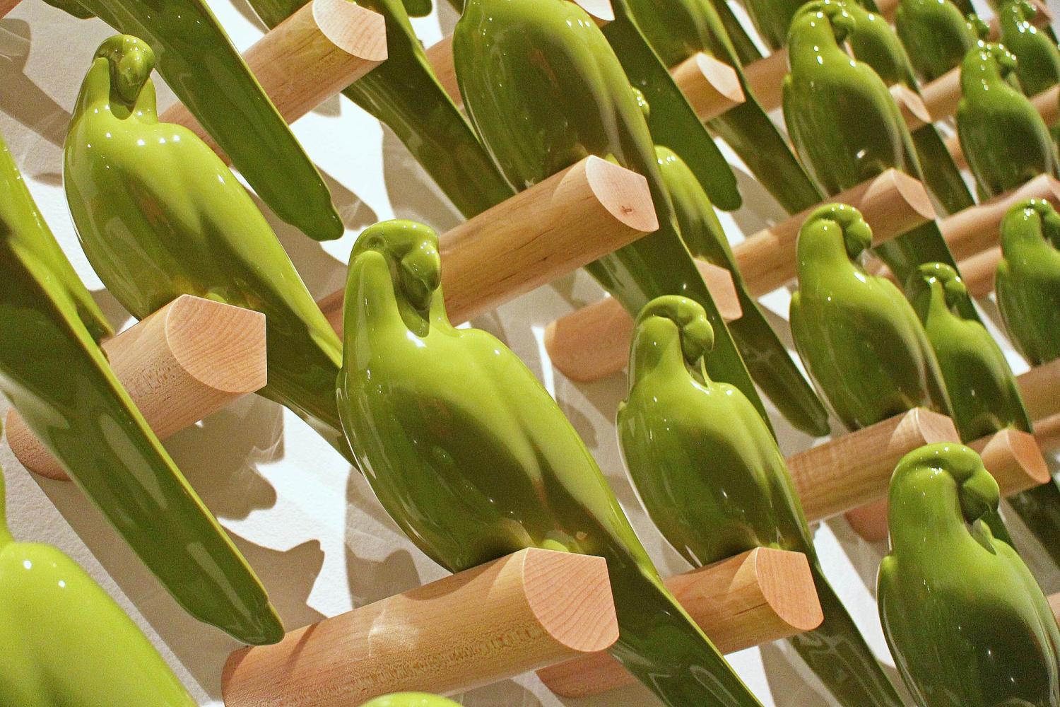 green ceramic birds on wall in art installation
