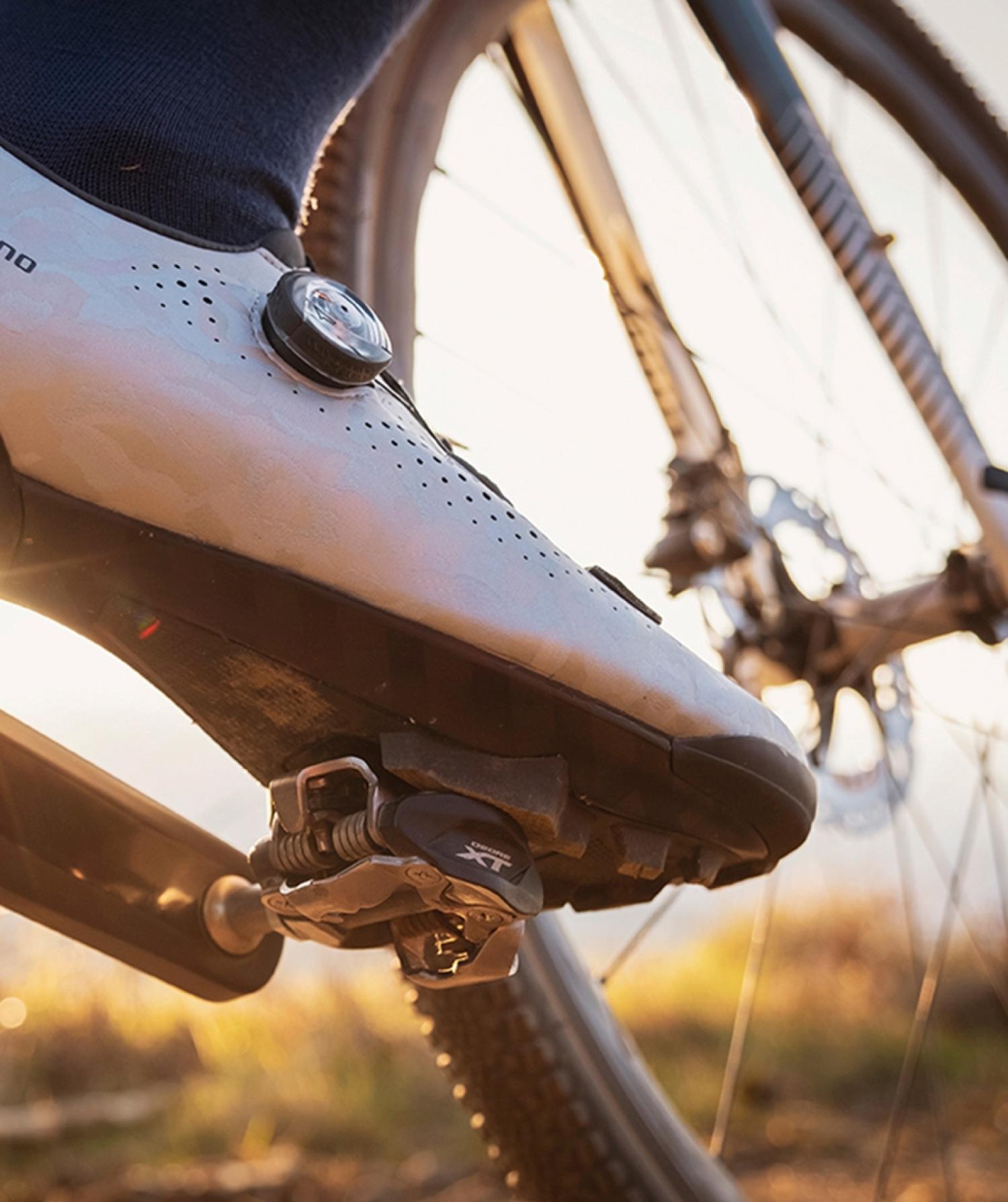 underside of white cycling shoe on bicycle pedal