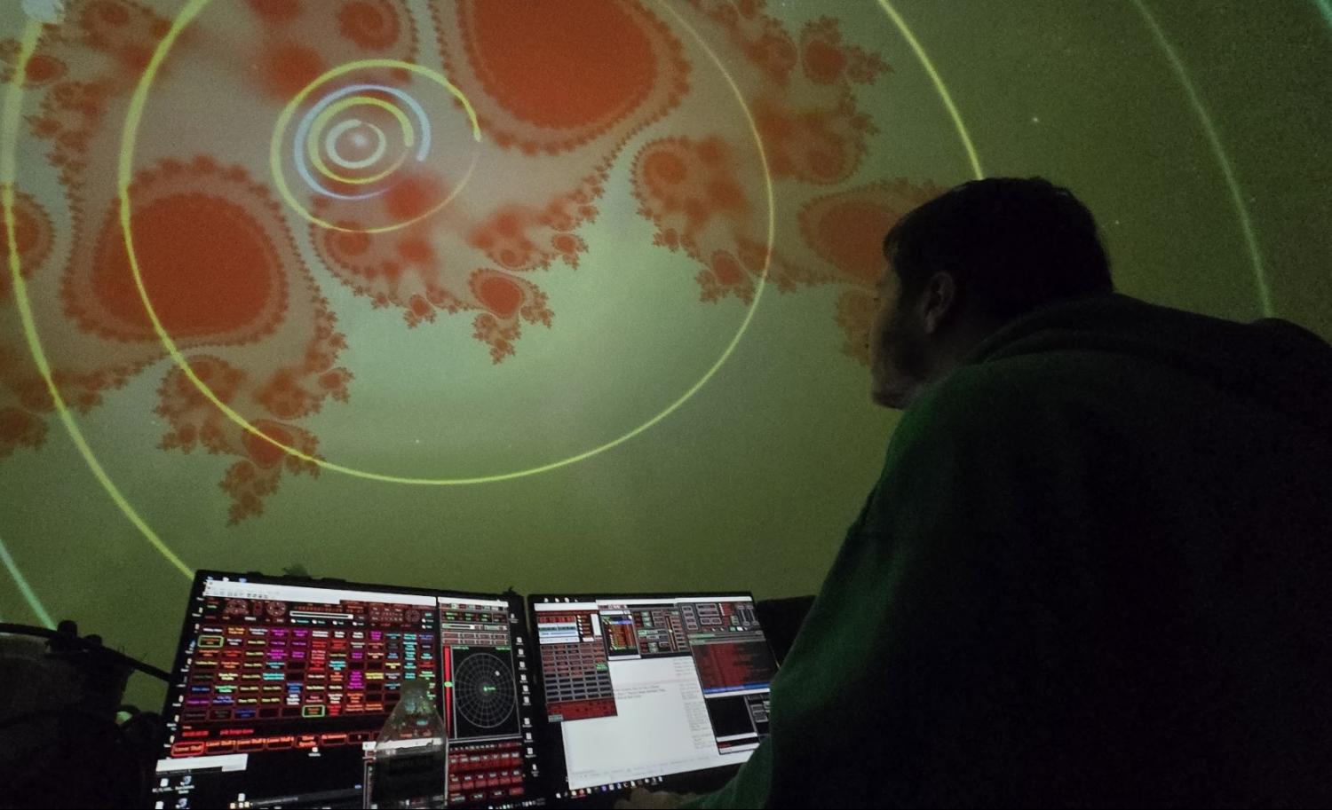 woman at computer looking up at Fiske Planetarium liquid sky show
