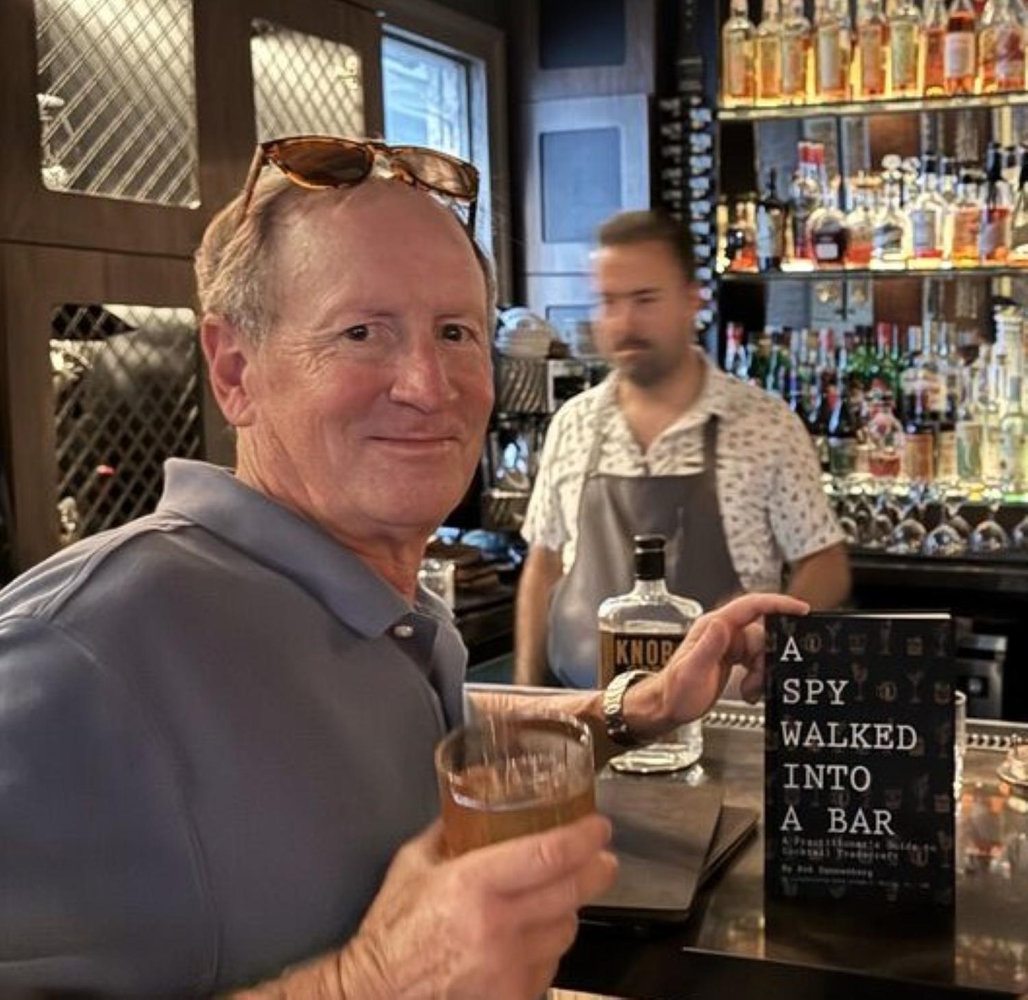Rob Dannenberg sitting at bar holding an Old Fashioned cocktail