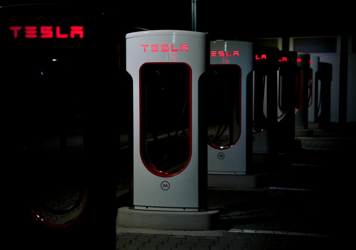 row of white Tesla charging stations