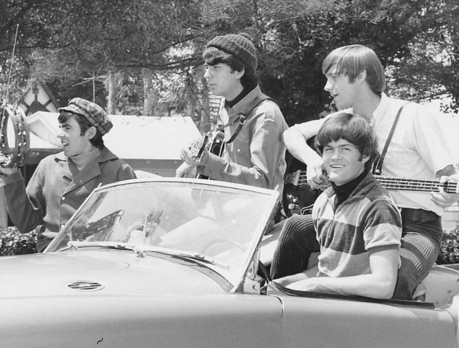 The Monkees members in a convertible