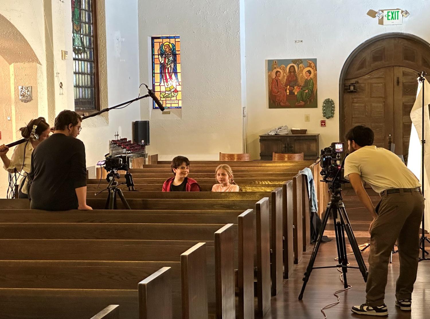two children sitting on church pew being filmed for short film Cherry Yogurt