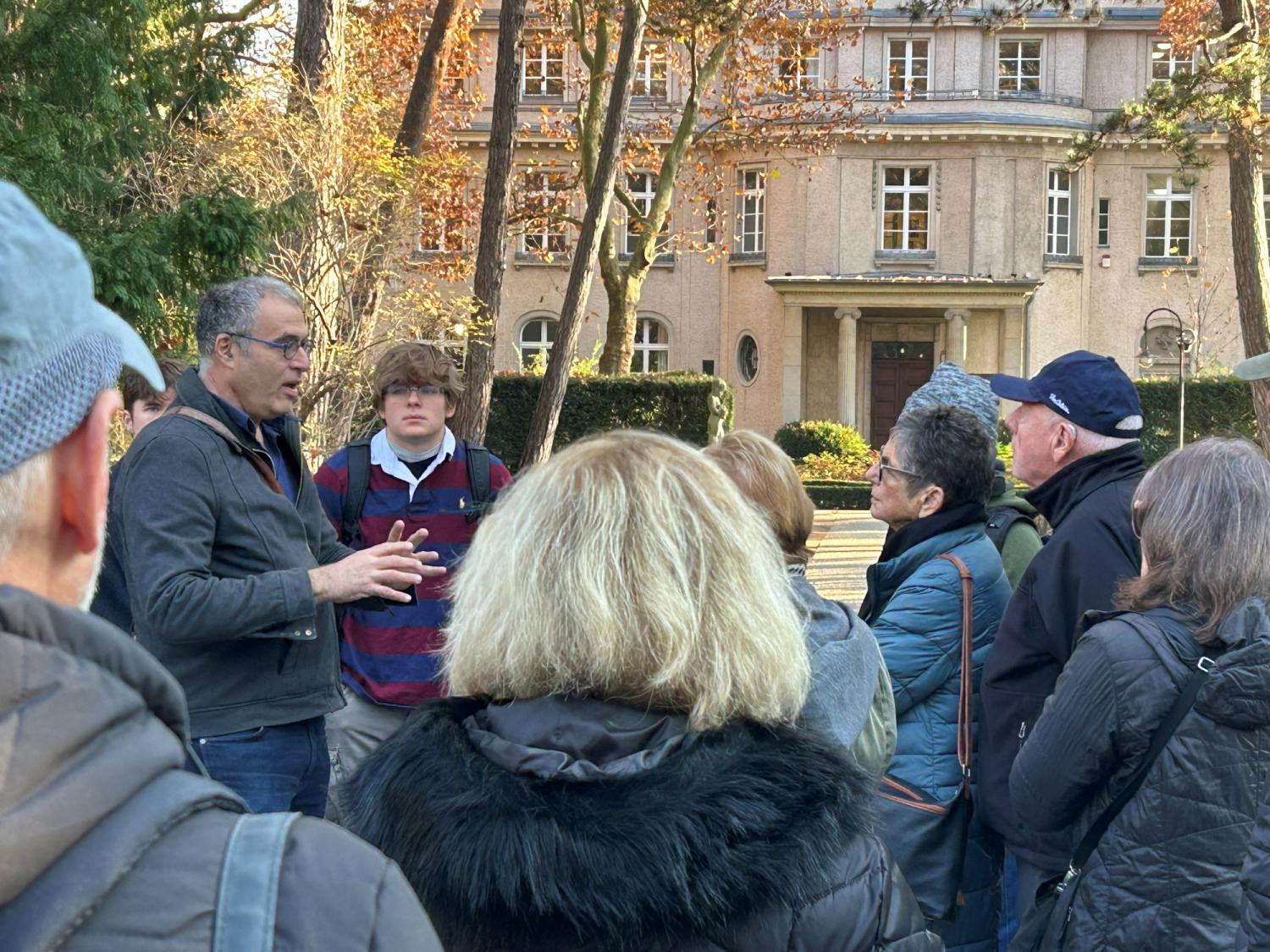 Man talking to group of people standing outdoors