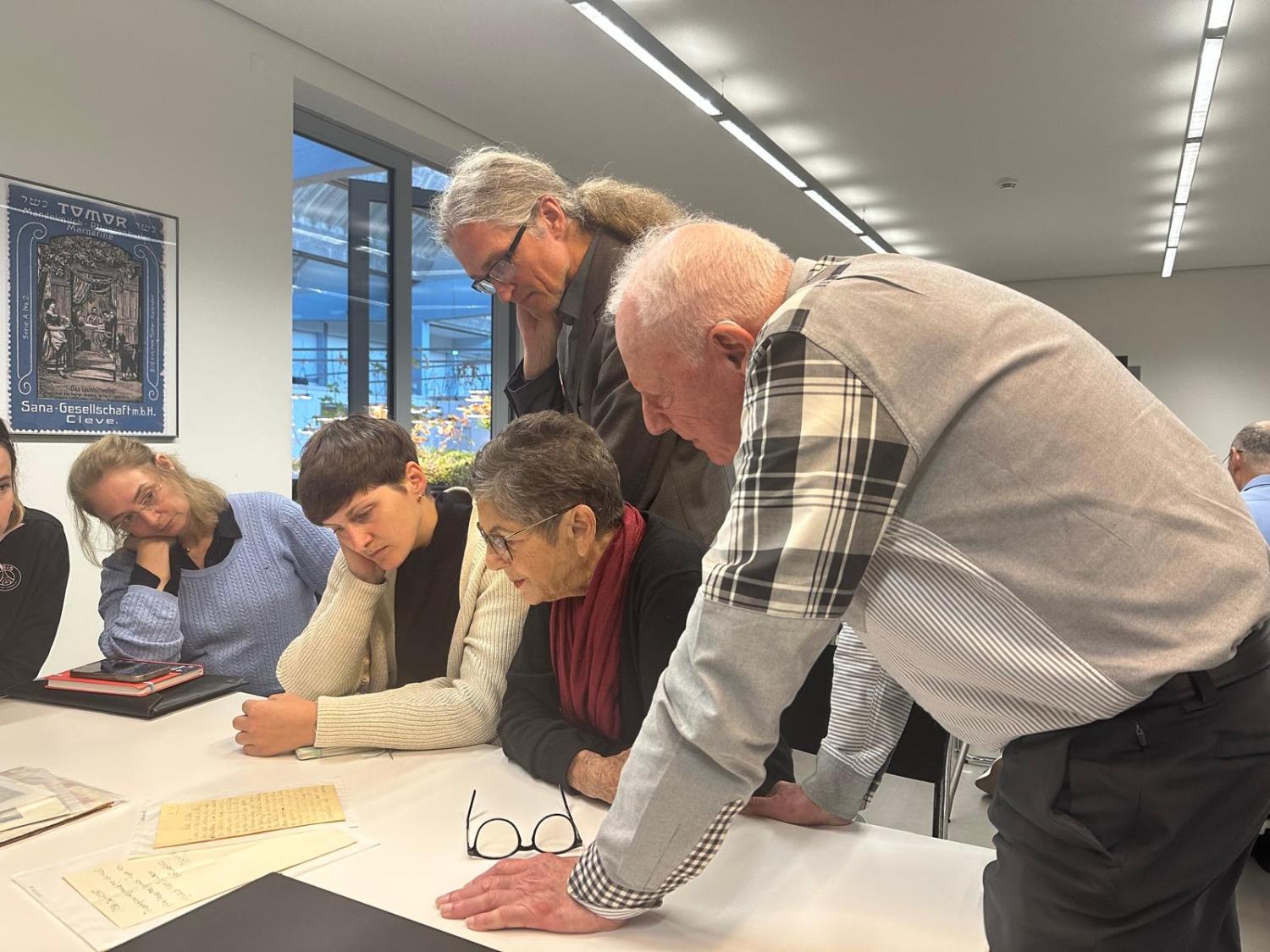 People leaning over table looking at documents