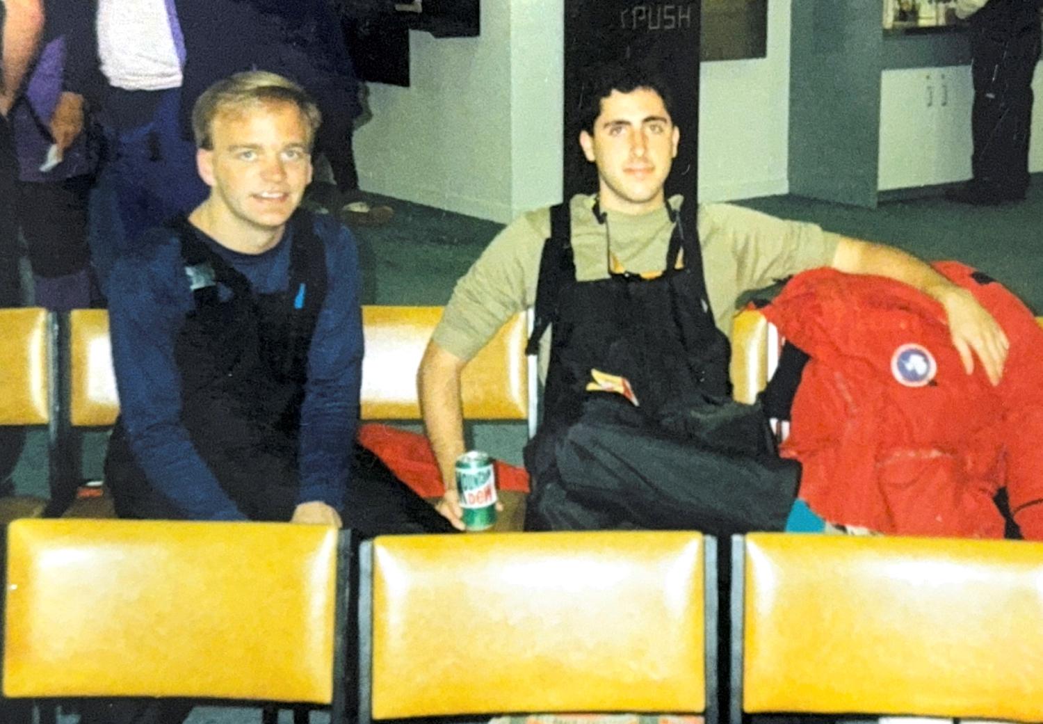 Mark Seefeldt and John Cassano wearing cold-weather gear indoors