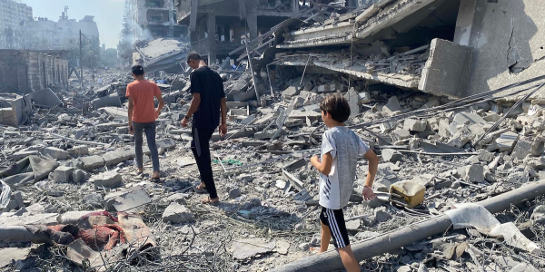 People walking through damage on Gaza Strip