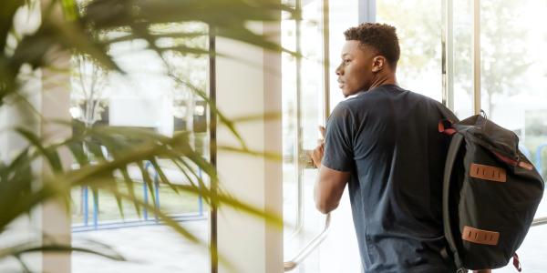 A Black male walking through a door