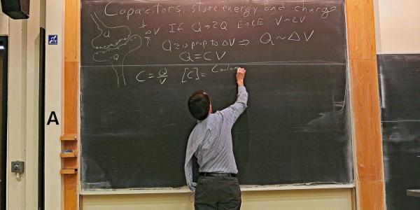 Eric Cornell writing on blackboard