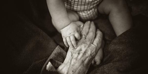 A baby holding a grandparent's hand