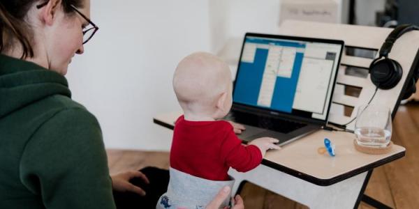 Woman working with a child on her lap