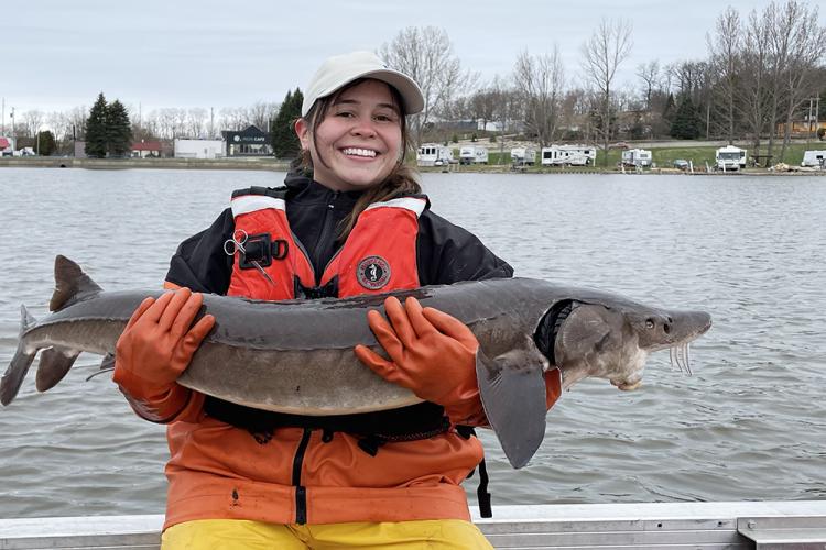 PhD candidate Natasha Myhal holds a sturgeon.