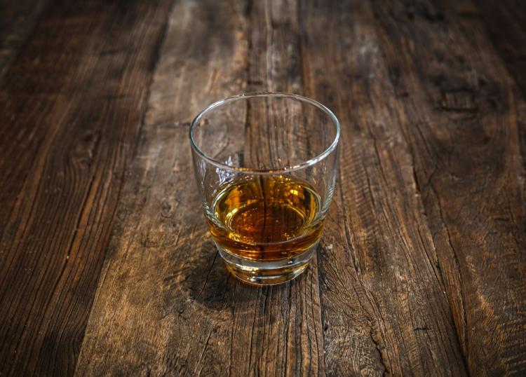 glass containing amber-colored alcohol