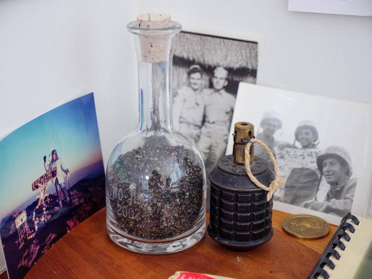 Sand of Iwo Jima and a hand grenade sitting on the desk of Dick Jessor.
