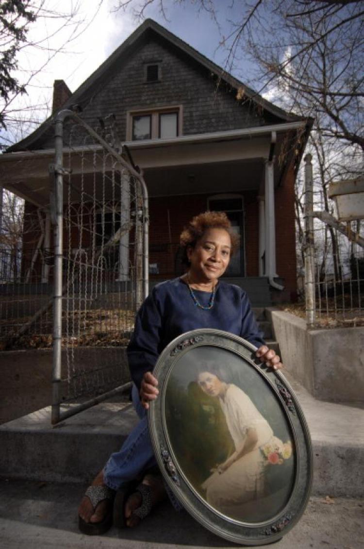 Polly McLean with a photo of Lucile Berkeley Buchanan in front of Buchanan's childhood home.