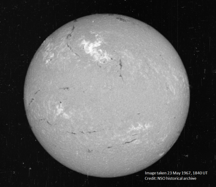 A view of the Sun on May 23, 1967, in a narrow visible wavelength of light called Hydrogen-alpha. The bright region in the top center region of brightness shows the area where the large flare occurred. Credit National Solar Observatory historical archive.