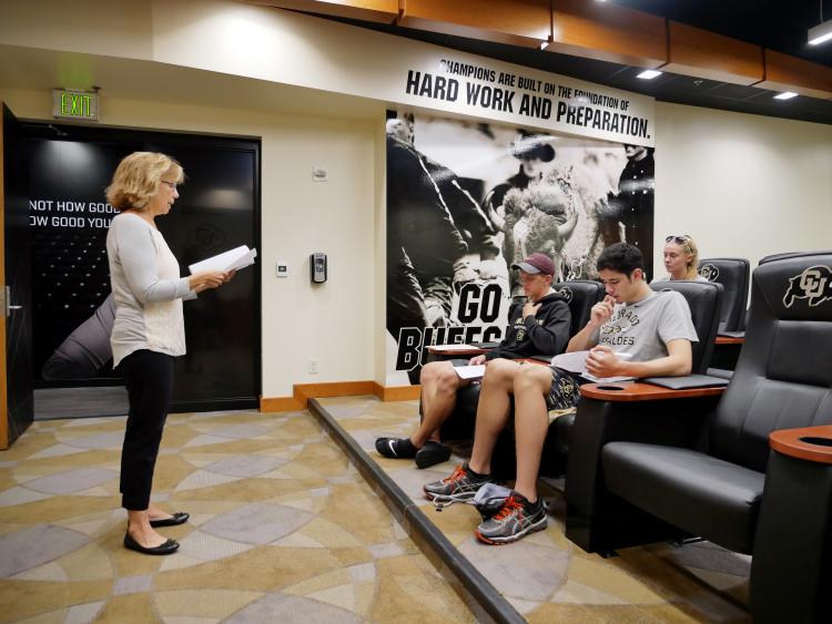 Theresa Hernandez, Psychology professor and associate dean, explains forms for a voluntary Pac-12 health and wellness study at the Coors Events Center. Freshmen student athletes are tested during on-boarding for athletic programs at CU Boulder. CU Boulder athletes have the option of participating in comprehensive health studies during the course of their student careers and beyond funded by grants from the Pac-12. (Photo by Glenn Asakawa/University of Colorado)