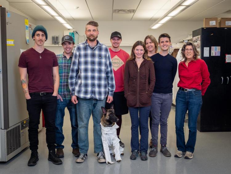 Dr. Watkins and her team in the lab with Navy veteran Jon Coulson and his service dog Xenna.