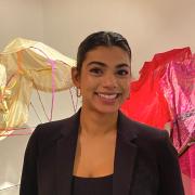 Shloka Dhar posing next to her thesis project made of metal and fabric.