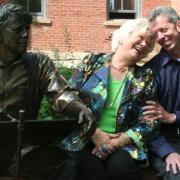 Roe Green and Bud Coleman share a laugh next to a statue of Robert Frost on the CU-Boulder campus.