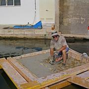 Researcher on top of concrete block submerged in the ocean.