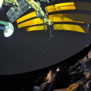 A group of audience watch video at the Fiske Planetarium of CU Boulder.