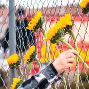 People place flowers at a memorial in front of the King Soopers in Boulder where a mass shooting took place on March 22, 2021.