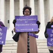 Demonstrators stand outside the Supreme Court