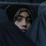 Afghani woman looking through a crowd