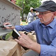 provost Russ Moore signing the beam