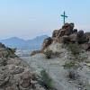 green cross on a rock outcropping at a U.S-Mexico border crossing path