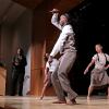 three dancers onstage with trumpet player